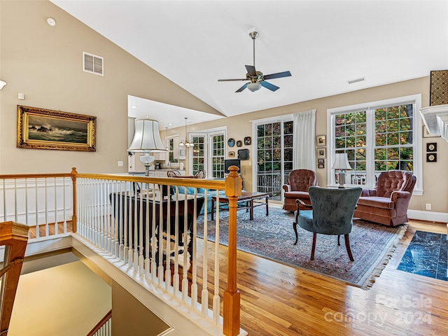 living room with ceiling fan, wood-type flooring, and lofted ceiling