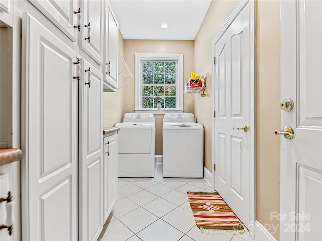 laundry area featuring light tile patterned flooring, cabinets, and independent washer and dryer