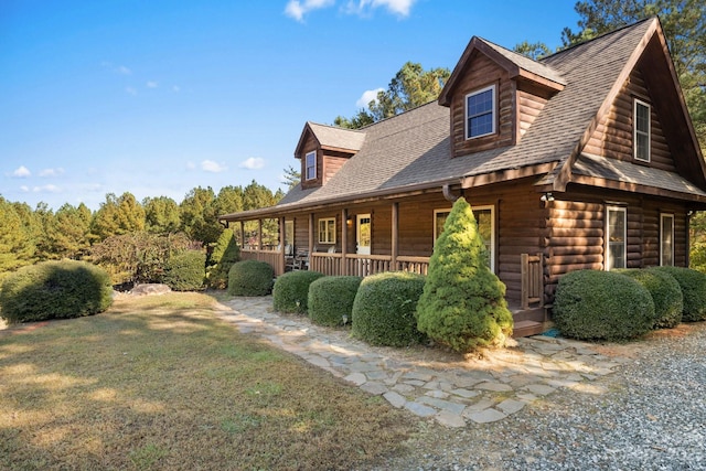 view of home's exterior with covered porch and a lawn