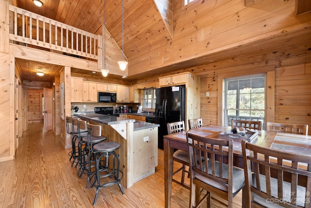 kitchen featuring light wood-type flooring, light brown cabinetry, high vaulted ceiling, and black appliances