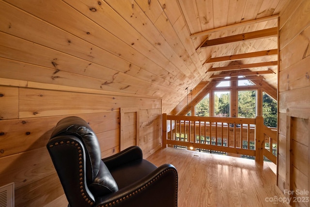 sitting room with wood walls, wood ceiling, vaulted ceiling, and light wood-type flooring