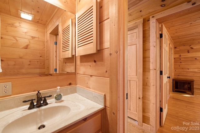 bathroom featuring vanity with extensive cabinet space, wooden ceiling, wood walls, and wood-type flooring