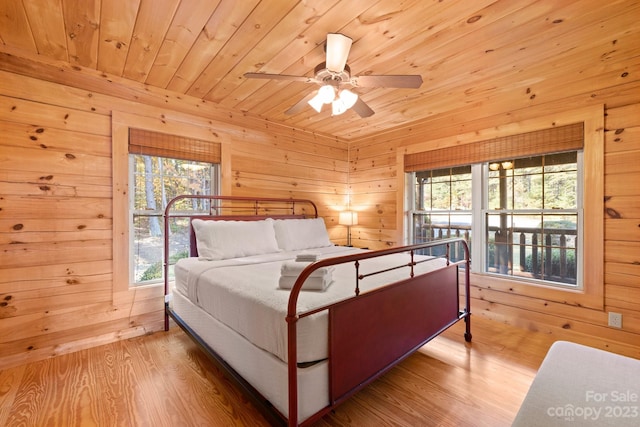 bedroom with wood ceiling, ceiling fan, wood walls, and light wood-type flooring