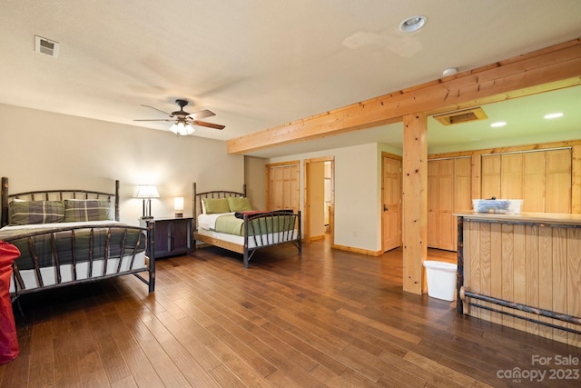 bedroom featuring dark hardwood / wood-style flooring, ceiling fan, and beam ceiling