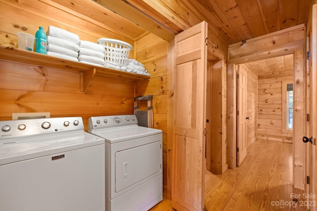 washroom featuring light hardwood / wood-style floors, washer and clothes dryer, wooden walls, and wood ceiling