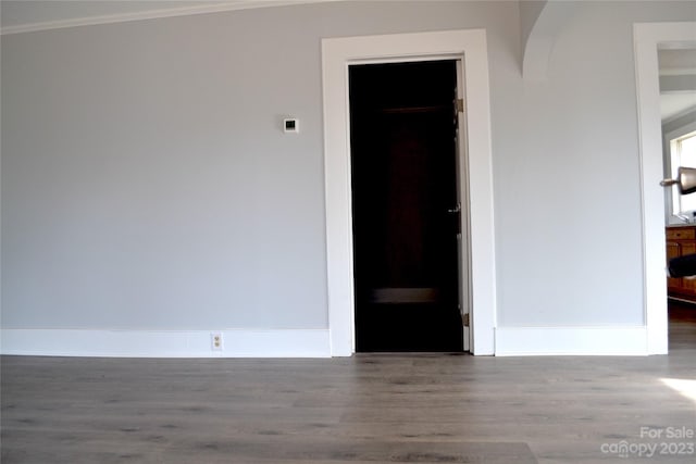 empty room with crown molding and hardwood / wood-style floors