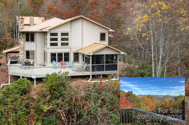 back of house with a sunroom and a deck