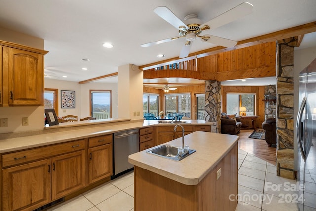 kitchen featuring kitchen peninsula, sink, light tile patterned floors, and appliances with stainless steel finishes