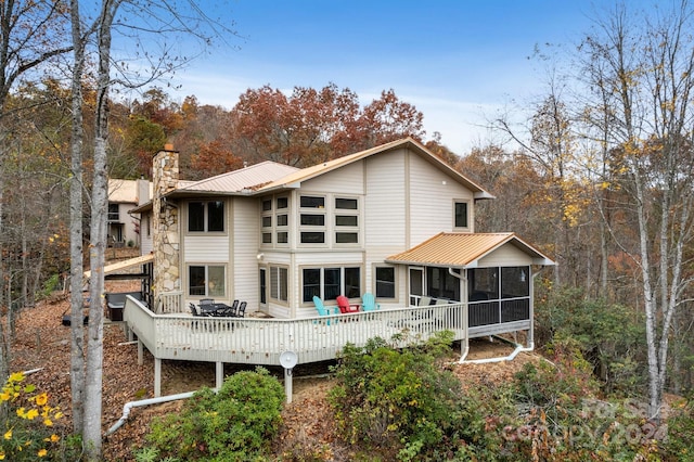 back of house with a sunroom and a wooden deck