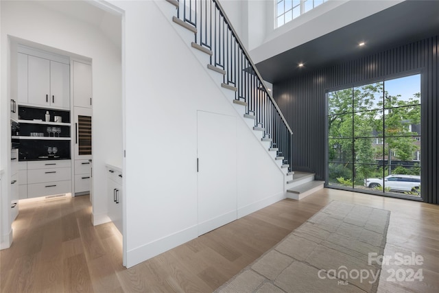 stairs featuring hardwood / wood-style floors and a high ceiling