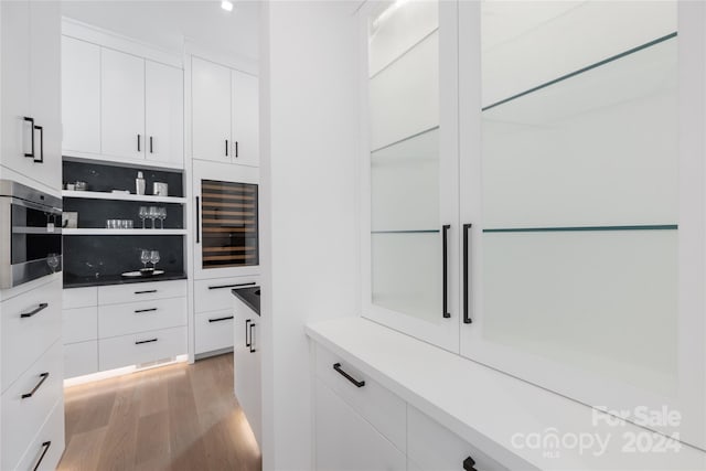 spacious closet featuring light hardwood / wood-style flooring and beverage cooler