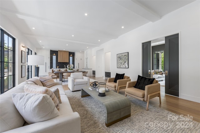 living room featuring light wood-type flooring and beamed ceiling