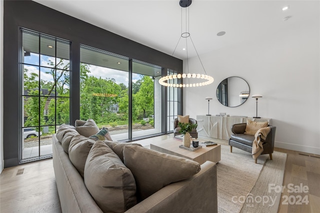 living room featuring light hardwood / wood-style flooring and a notable chandelier