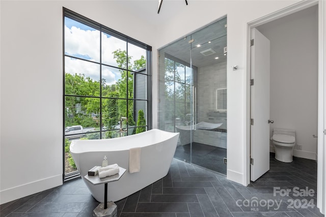 bathroom with plus walk in shower, toilet, and tile patterned floors