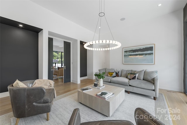 living room featuring light wood-type flooring and a chandelier