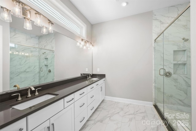 bathroom with marble finish floor, a marble finish shower, baseboards, and a sink