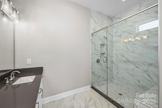 bathroom with a marble finish shower, marble finish floor, vanity, and baseboards