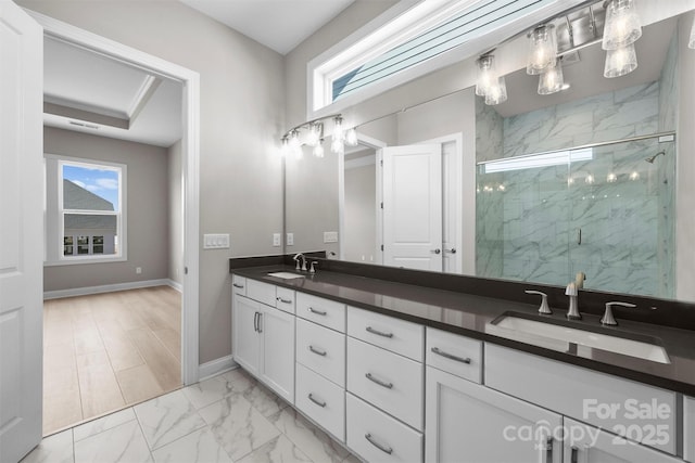 full bathroom featuring a sink, marble finish floor, a marble finish shower, a wealth of natural light, and double vanity