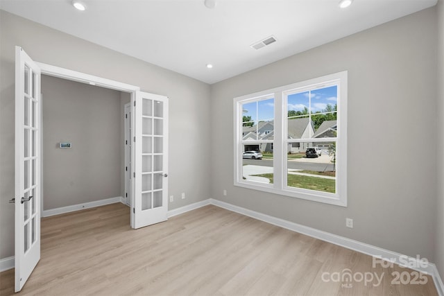 spare room with light wood-style floors, french doors, visible vents, and baseboards