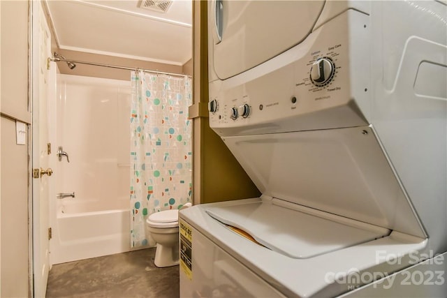 bathroom with toilet, shower / tub combo with curtain, and stacked washer and dryer