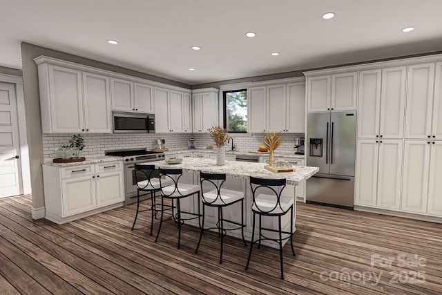 9999 Sourwood Rd, Canton, NC 28716 - kitchen with appliances with stainless steel finishes, wood finished floors, a kitchen breakfast bar, recessed lighting, and a center island