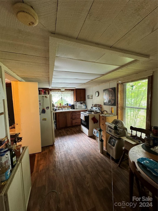 kitchen with white appliances, brown cabinets, and dark wood-style floors