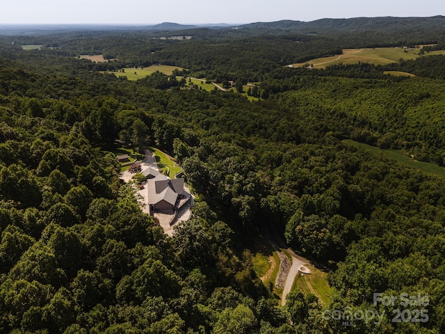 drone / aerial view featuring a wooded view