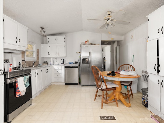 kitchen with ceiling fan, appliances with stainless steel finishes, light tile flooring, vaulted ceiling, and white cabinetry