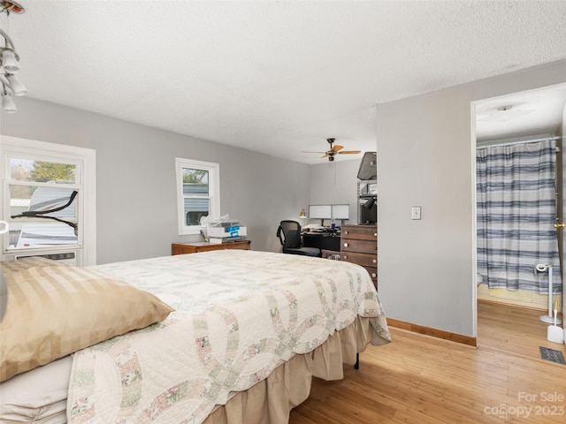 bedroom featuring ceiling fan, a textured ceiling, and light hardwood / wood-style floors