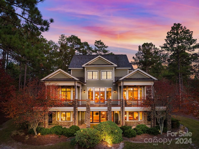 back house at dusk with a balcony