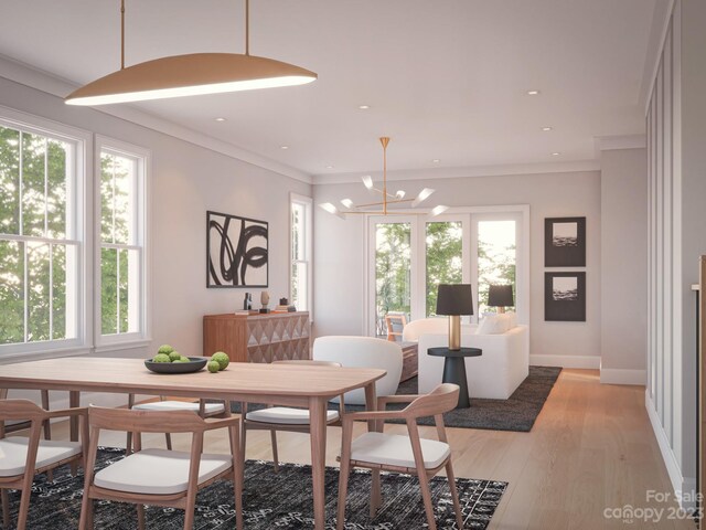 dining area featuring light hardwood / wood-style flooring, ornamental molding, and a chandelier