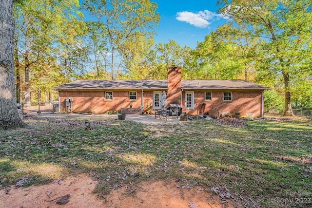 rear view of property with a yard and a patio