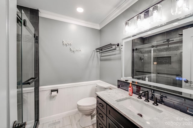 bathroom with tile floors, a shower with shower door, toilet, vanity, and crown molding