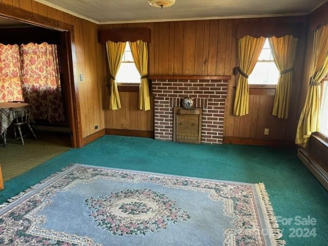 unfurnished living room with wooden walls, dark colored carpet, ornamental molding, and a brick fireplace