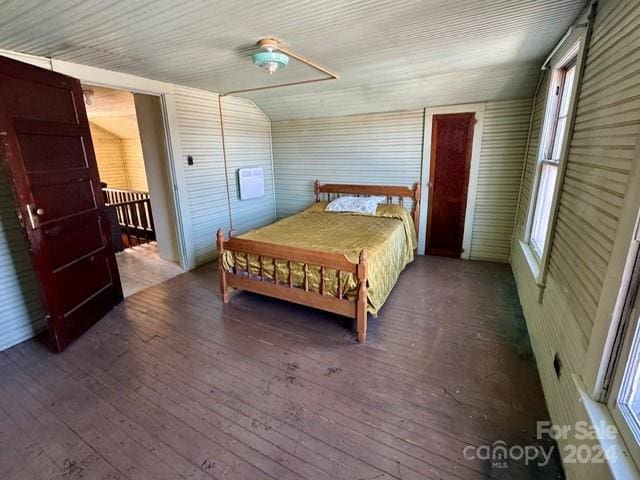 bedroom featuring ceiling fan, dark wood-type flooring, and multiple windows