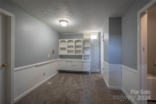 carpeted spare room with a textured ceiling and washer / clothes dryer