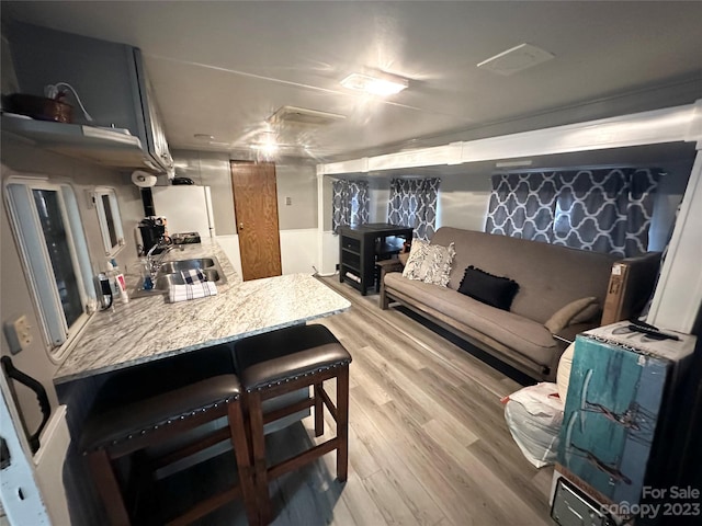 living room with sink and light wood-type flooring