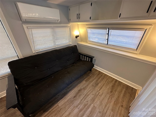 living room with wood-type flooring and a wall unit AC