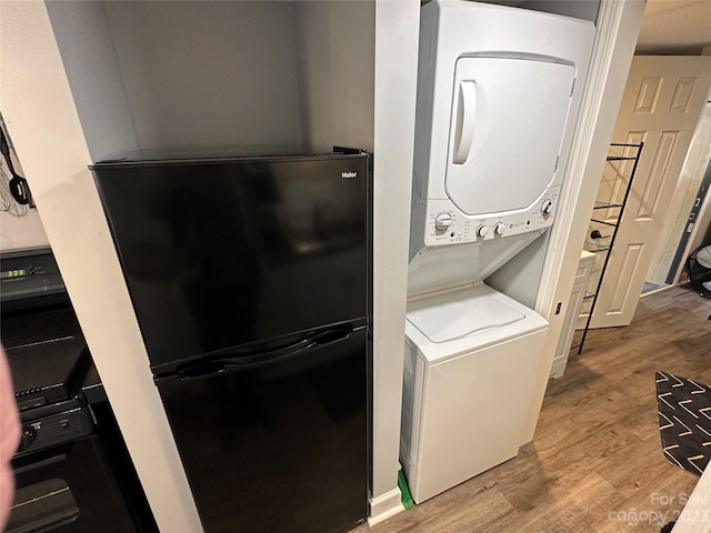 laundry area featuring light hardwood / wood-style flooring and stacked washer / dryer