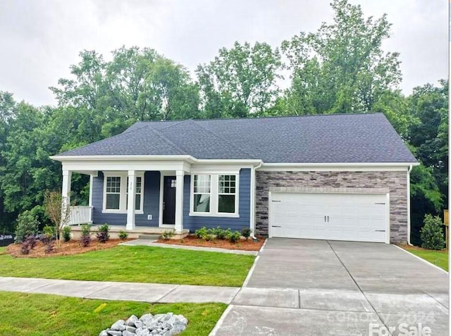 view of front facade with a garage, a front lawn, and a porch