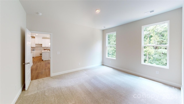 unfurnished room featuring light carpet