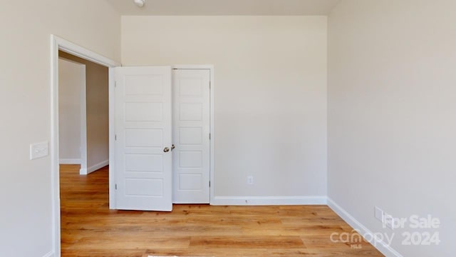 unfurnished bedroom with a closet and hardwood / wood-style flooring