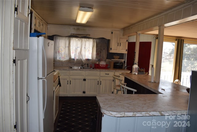 kitchen with white cabinetry, white fridge, wood ceiling, and kitchen peninsula