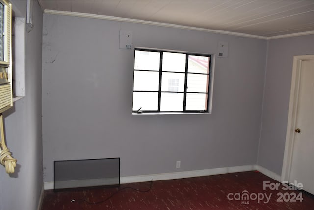 empty room featuring crown molding and dark wood-type flooring