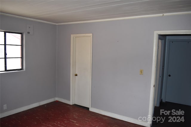 spare room with ornamental molding and dark wood-type flooring