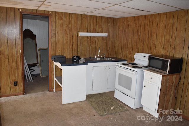 kitchen featuring wood walls, white cabinetry, white range with electric stovetop, and a drop ceiling