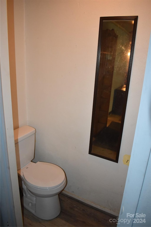 bathroom with hardwood / wood-style flooring and toilet