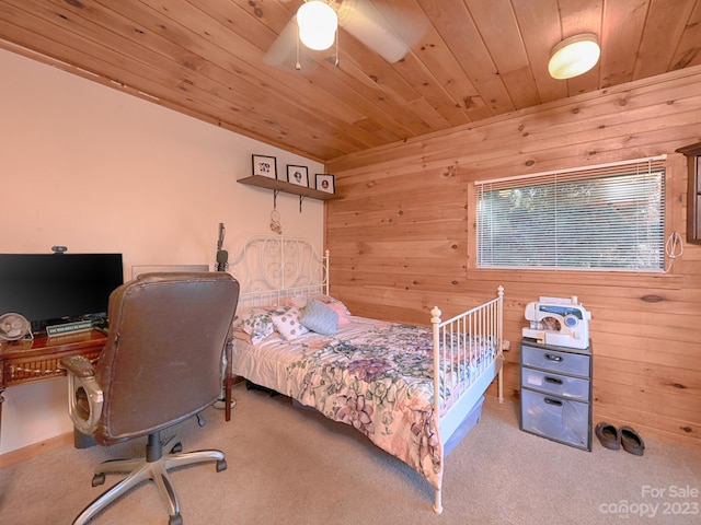 carpeted bedroom with ceiling fan, wood ceiling, and wood walls