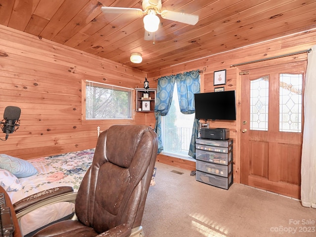 interior space featuring ceiling fan, wood walls, and wood ceiling