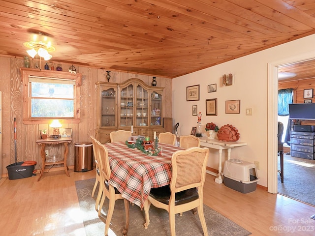 dining area featuring wood ceiling, light hardwood / wood-style flooring, and wooden walls